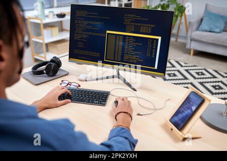 High angle view at young IT programmer writing code for mobile devices at home office workplace Stock Photo