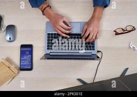 Minimal top view at male hands typing on keyboard and writing code for mobile app Stock Photo