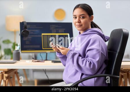 Portrait of young woman as computer programmer looking at camera at workplace, copy space Stock Photo