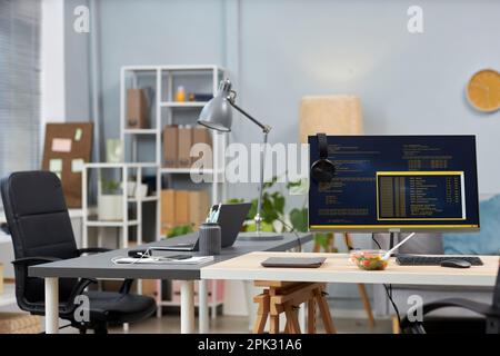 Background image of empty office with two desks and computer code on screens, copy space Stock Photo