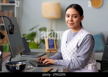 Portrait of young woman as female computer programmer looking at camera at workplace, copy space Stock Photo