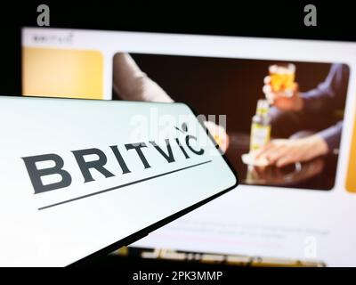 Smartphone with logo of British soft drinks company Britvic plc on screen in front of business website. Focus on center-left of phone display. Stock Photo