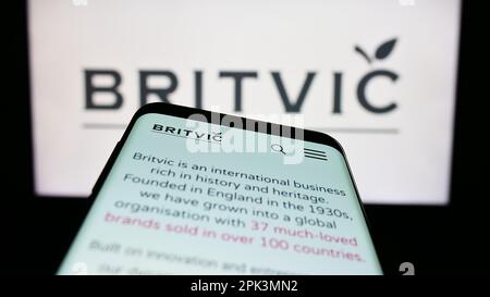 Mobile phone with webpage of British soft drinks company Britvic plc on screen in front of business logo. Focus on top-left of phone display. Stock Photo