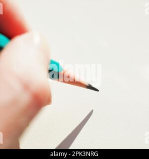 Green graphite pencil in female hand with sunlight. Stock Photo