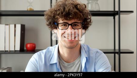 Smiling man with eyeglasses using laptop working at home Stock Photo