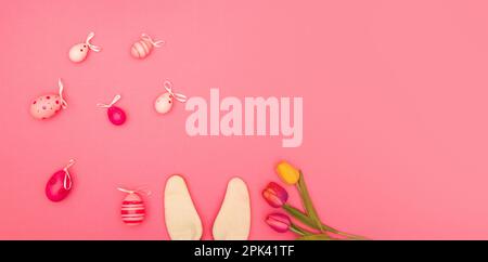 Pink background with Easter eggs, bunny ears and flowers offers plenty of room for copying Stock Photo