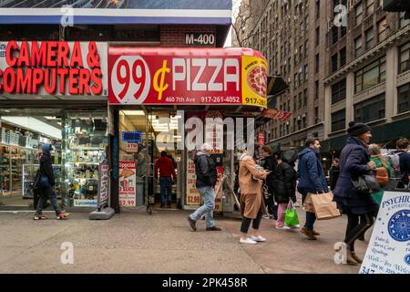 Hungry pizza lovers eat at a 99 Cent Pizzeria in Midtown Manhattan in New York on Friday, March 31, 2023.  (© Richard B. Levine) Stock Photo