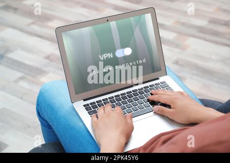 Man using laptop with switched on VPN indoors, closeup Stock Photo