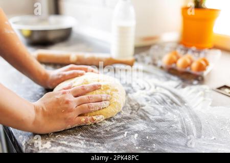 Womens hands kneading dough on table sprinkle with flour. Kneading dough Stock Photo