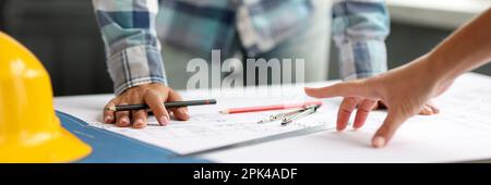 Architect discussing project with colleague using blueprints Stock Photo
