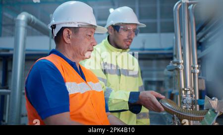Engineer specialist checking and controlling machine in industrial factory Stock Photo