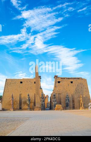 The Pylon of Ramesses ll with the Eastern Obelisk and the Two Colossi of the King seated on his Throne, Luxor Temple, Luxor, Egypt, North East Africa Stock Photo