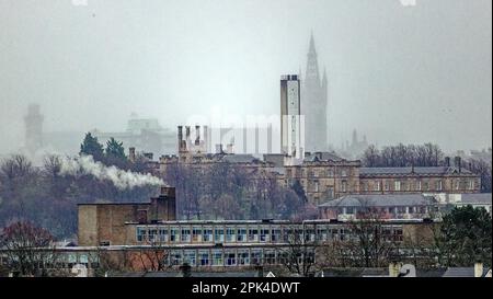 Glasgow, Scotland, UK 5th April, 2023. UK Weather: Wet and misty saw the city disappear behind local landmarks amidst the April showers.Glasgow university and its gothic tower ghosted  behind gartnavel hospital and knightswood high comprehensive school Credit Gerard Ferry/Alamy Live News Stock Photo