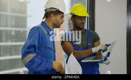 Contractor worker and professional architect holding laptop talking Stock Photo
