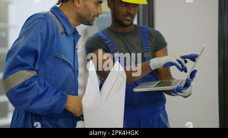 Contractor worker and professional architect holding laptop talking Stock Photo