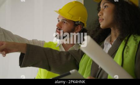 Engineers using tablet talking and brainstorming together on construction site Stock Photo