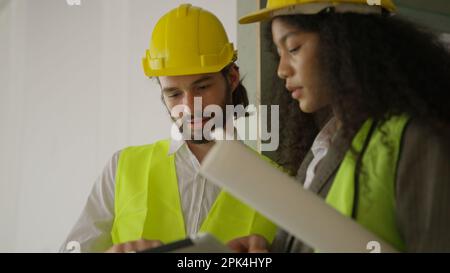 Engineers using tablet talking and brainstorming together on construction site Stock Photo
