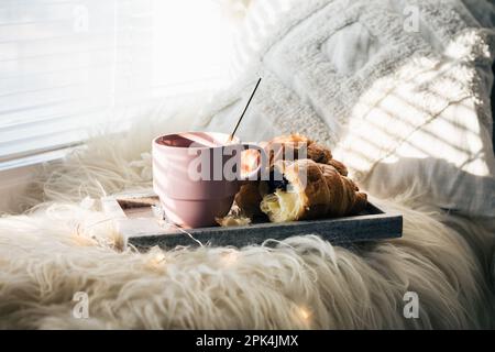 Cup of coffee with chocolate croissants on a windowsill. Stock Photo