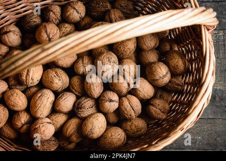 Harvest of walnuts in a basket, top view. Stock Photo