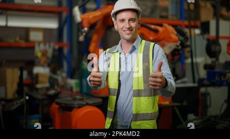 Portrait of male engineer working with robotic arms in factory Stock Photo