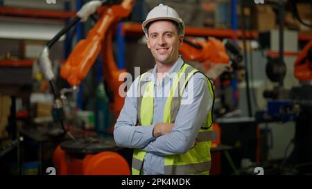 Portrait of male engineer working with robotic arms in factory Stock Photo