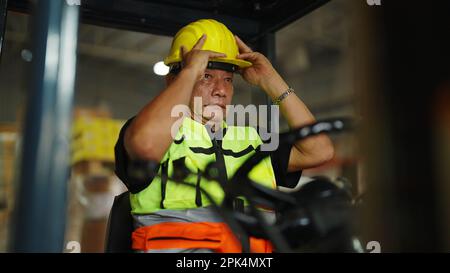 Warehouse worker working on forklift in the factory Stock Photo