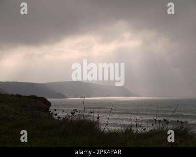 God Rays break through orange clouds over Widemouth Bay, Cornwall, during Storm Ophelia, 15 October 2017 Stock Photo