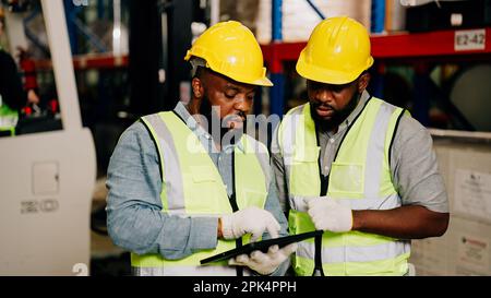 Two warehouse workers checking and controlling boxes in warehouse Stock Photo