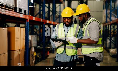 Two warehouse workers checking and controlling boxes in warehouse Stock Photo