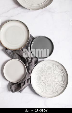 Flat lay textured ripple empty grey ceramic plate with napkin on grey background Stock Photo