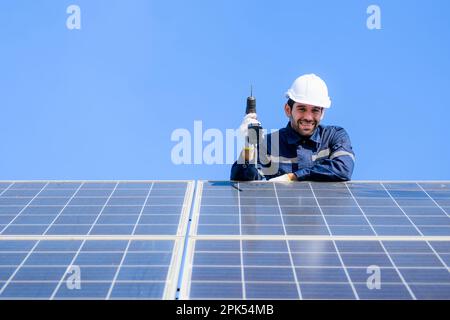 Technician worker installing solar panels at solar cell farm Stock Photo
