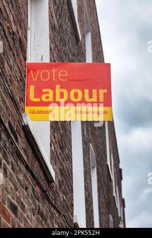 A political sign on a brick wall in Islington district in London, urging the voters to support the Labour Party in the local parliamentary elections. Stock Photo