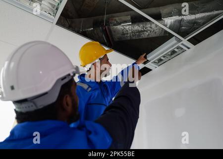 Engineers technicians with safety helmet working installing and checking system Stock Photo