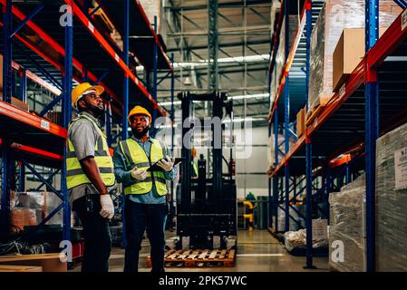 Two warehouse workers checking and controlling boxes in warehouse Stock Photo