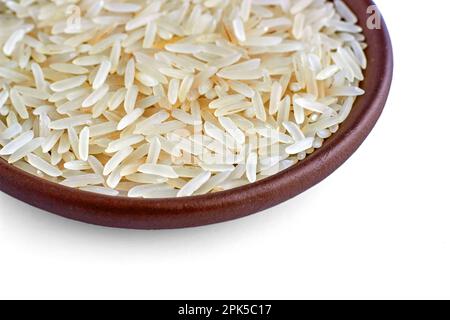 Indian basmati rice in a clay ceramic bowl close-up isolated on a white background. Stock Photo