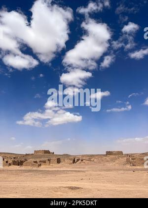 Merzouga, Morocco, Africa: panoramic road in the Sahara desert, ruined houses in an abandoned nomadic village near the fossil mines of Black Mountain Stock Photo