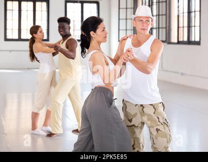 Four dancers exercising bachata movements Stock Photo