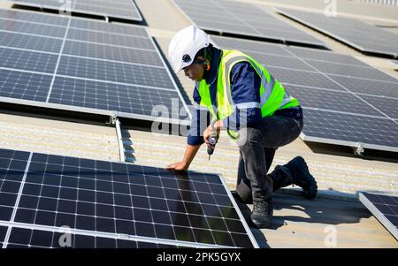 Engineer technician with safety helmet checking and inspecting solar system Stock Photo
