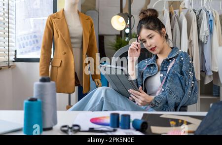 Confident female fashion designer enjoying with process of creating new clothes Stock Photo