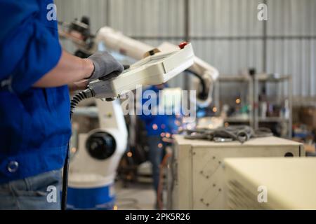 Engineer technician controlling robotic arms on computer laptop Stock Photo