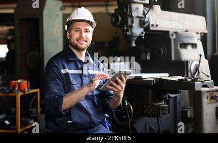 Professional male technician engineer using tablet checking machine Stock Photo