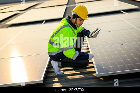 Engineer working at solar cell farm power plant with sunset in evening Stock Photo