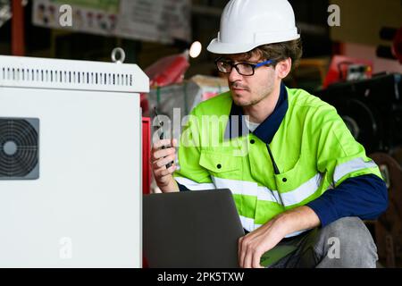Technician engineer holding robot controller checking and repairing machine Stock Photo