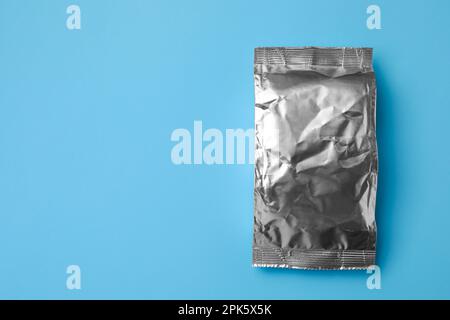 Blank foil package on light blue background, top view. Space for text Stock Photo