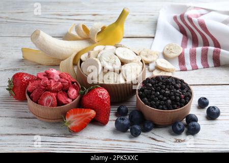 Different freeze dried and fresh fruits on white wooden table Stock Photo