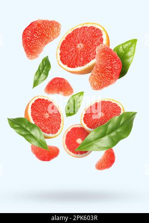 Tasty ripe grapefruits and green leaves falling on light background Stock Photo