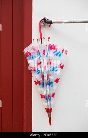 Red, blue and white plastic umbrella. Stock Photo