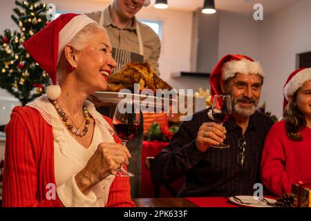 Happy family enjoying with Christmas celebration eating food together at home Stock Photo
