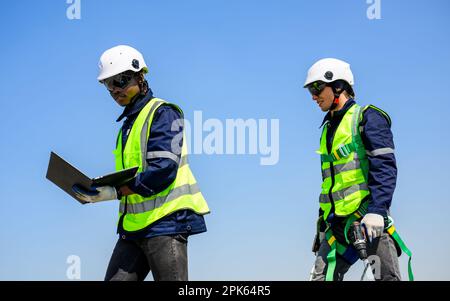 Two technicians workers checking photovoltaic panels on solar farm Stock Photo