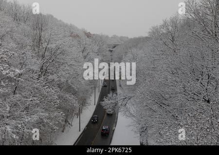 Tail lights from cars provide a splash of colour on Rosedale Valley Road is seen in Toronto, Canada, during the first snowfall of the winter Stock Photo
